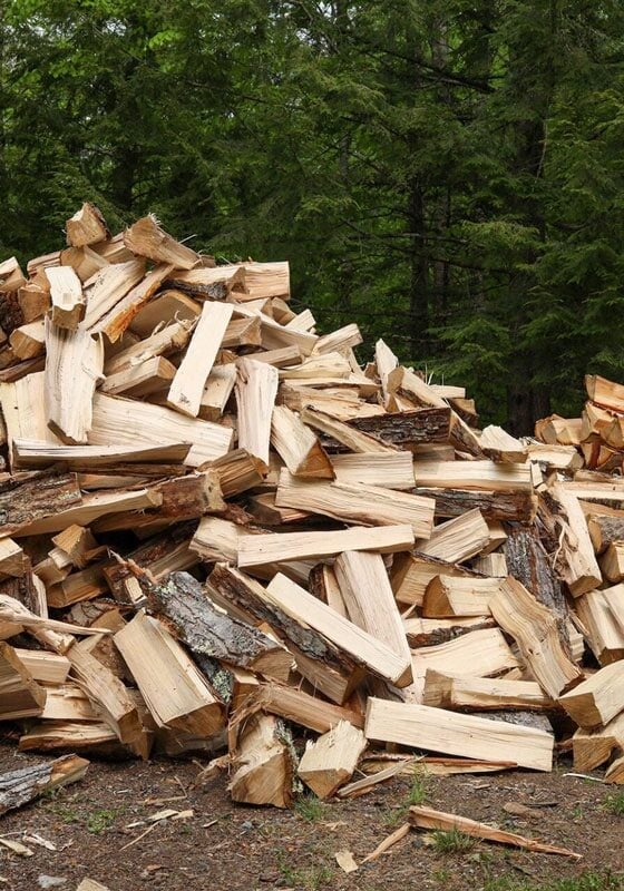 A large pile of chopped firewood. The wood appears to be neatly cut and stacked.